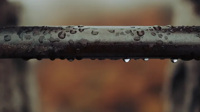 Gouttes d'eau sur une canalisation métallique, symbole des fuites cachées que Scan-Eau localise sans casse