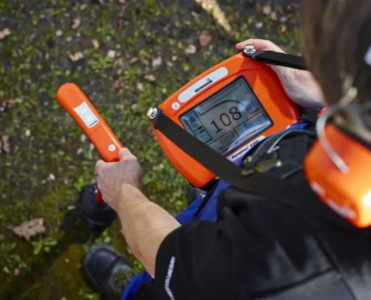 Technicien équipé d'un casque et d'un corrélateur acoustique pour repérer le bruit d'une fuite d'eau